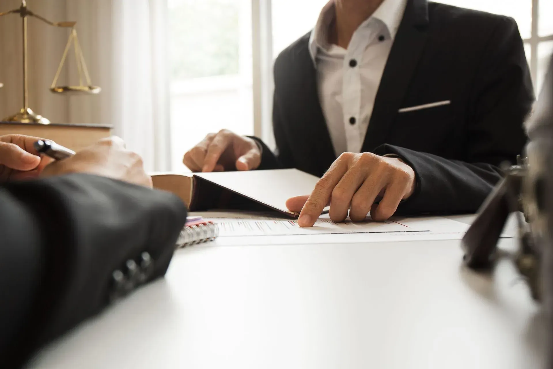An attorney and a client reviewing claim paperwork across a desk